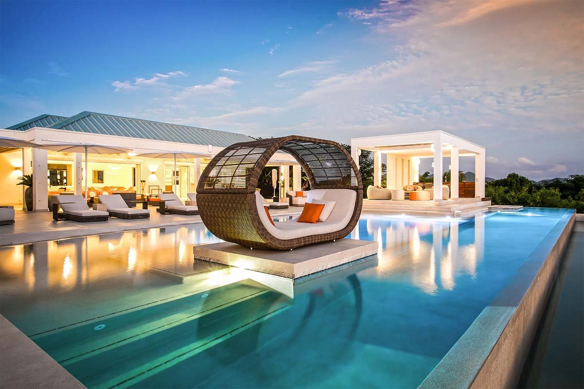 L-shaped saltwater pool with built-in seating, daybed, and gazebo at Villa Avanti, St. Martin.