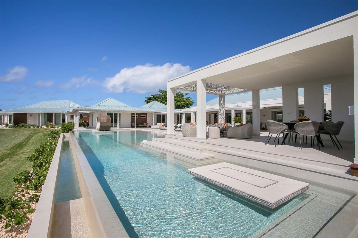 L-shaped saltwater pool with built-in seating, daybed, and gazebo at Villa Avanti, St. Martin.