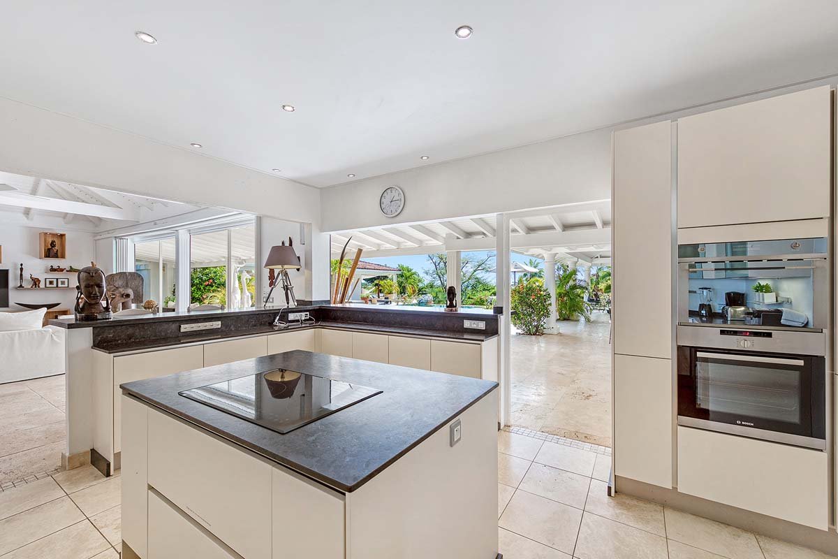 Interior de cocina moderna y abierta en la villa La Pinta, St. Maarten con vista a la isla