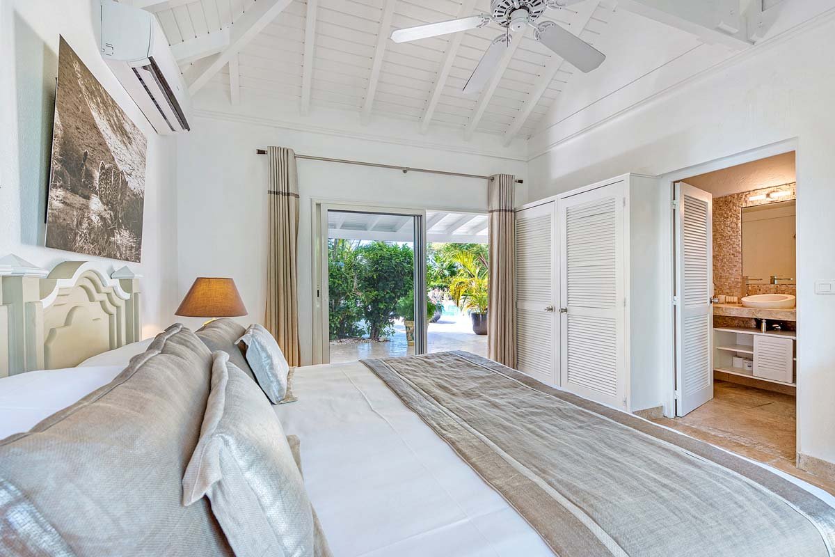 Interior de dormitorio luminoso y aireado en la villa La Pinta en St. Maarten con vista al jardín
