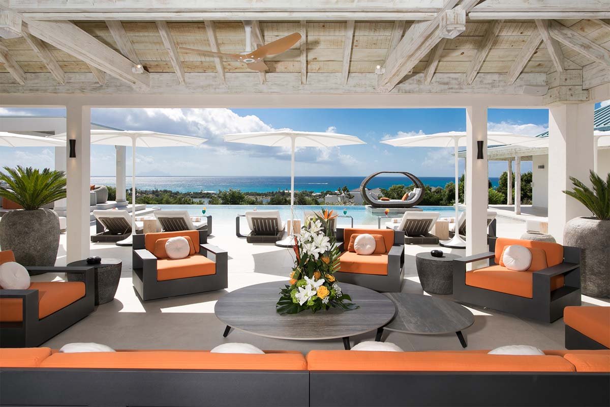 Covered outdoor seating area with ocean views and lounge seating at Villa Avanti, St. Martin
