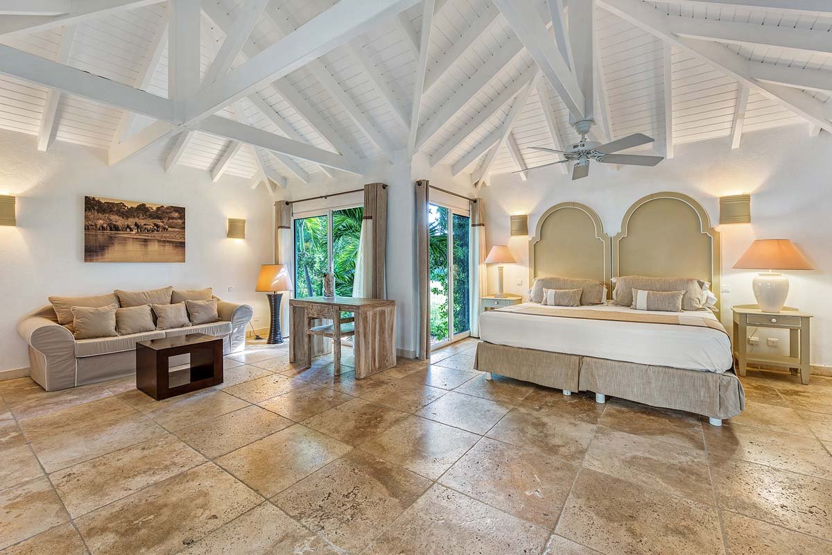 Interior de dormitorio luminoso en la villa La Pinta, St. Maarten con vista al jardín