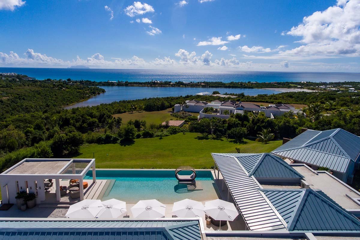 Aerial view of Villa Avanti showcasing its L-shaped pool and ocean views in Terres Basses, St. Martin