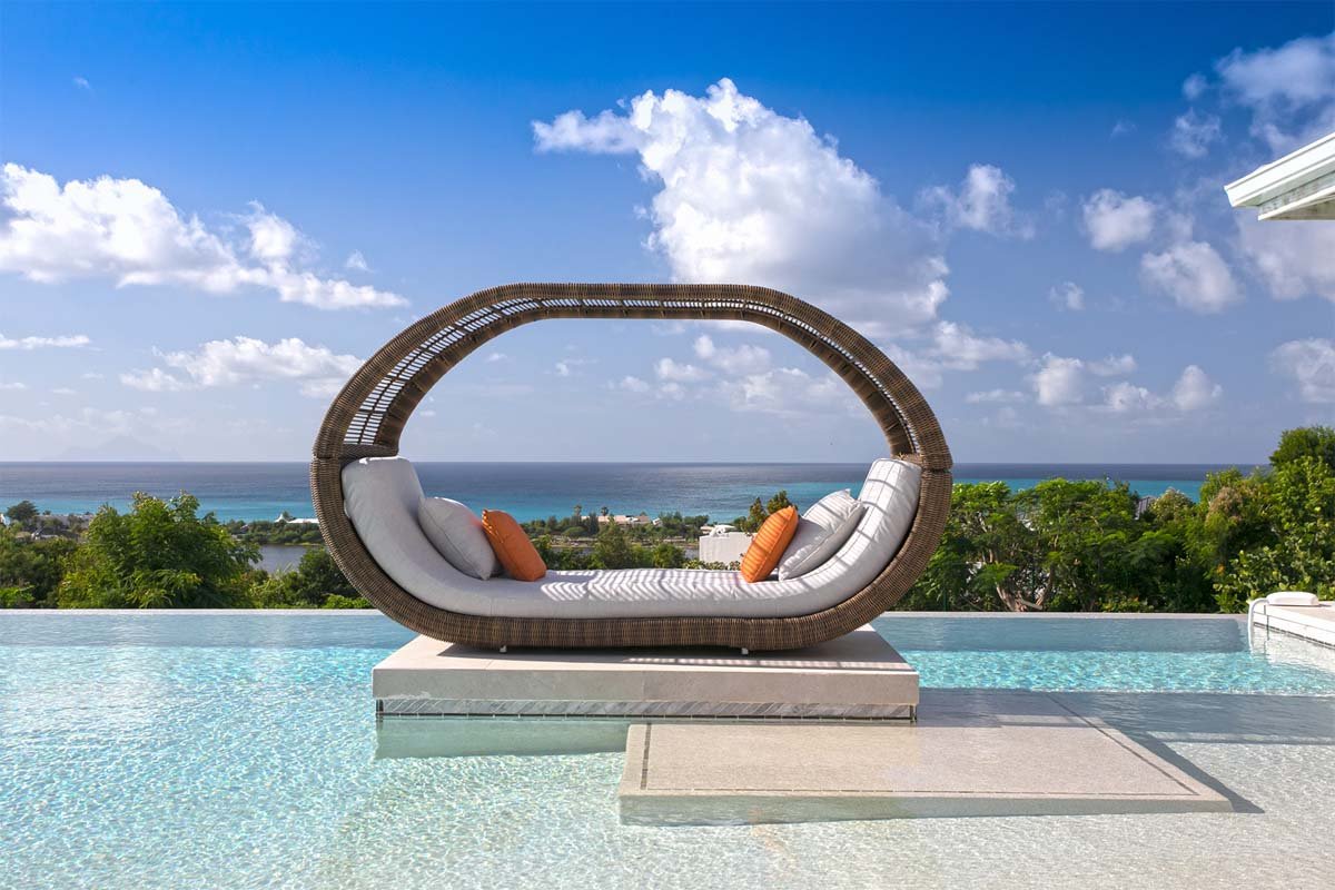 L-shaped saltwater pool with built-in seating, daybed, and gazebo at Villa Avanti, St. Martin