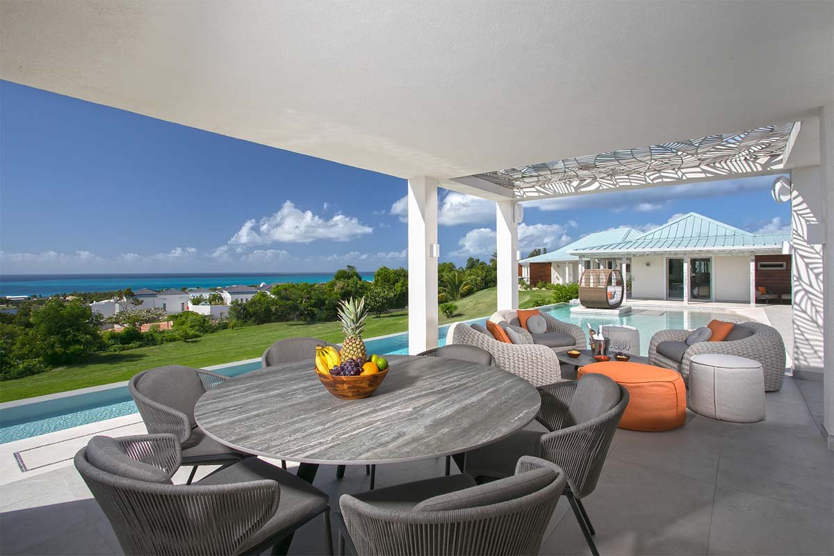 L-shaped saltwater pool with built-in seating, daybed, and gazebo at Villa Avanti, St. Martin.