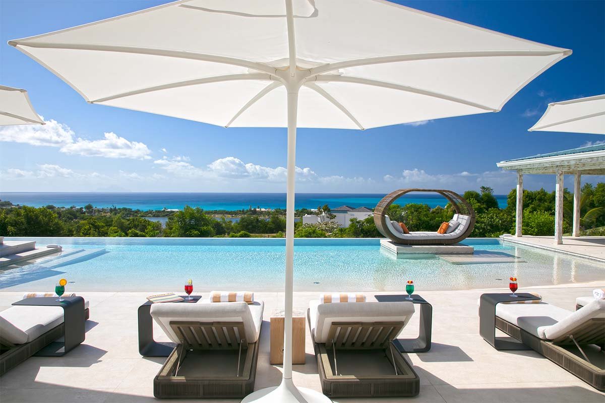 L-shaped saltwater pool with built-in seating, daybed, and gazebo at Villa Avanti, St. Martin.