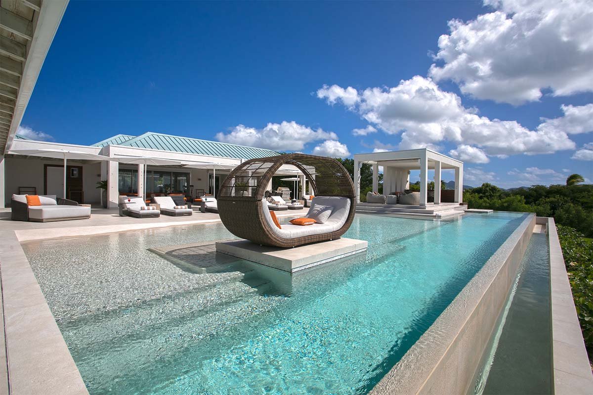 L-shaped saltwater pool with built-in seating, daybed, and gazebo at Villa Avanti, St. Martin.