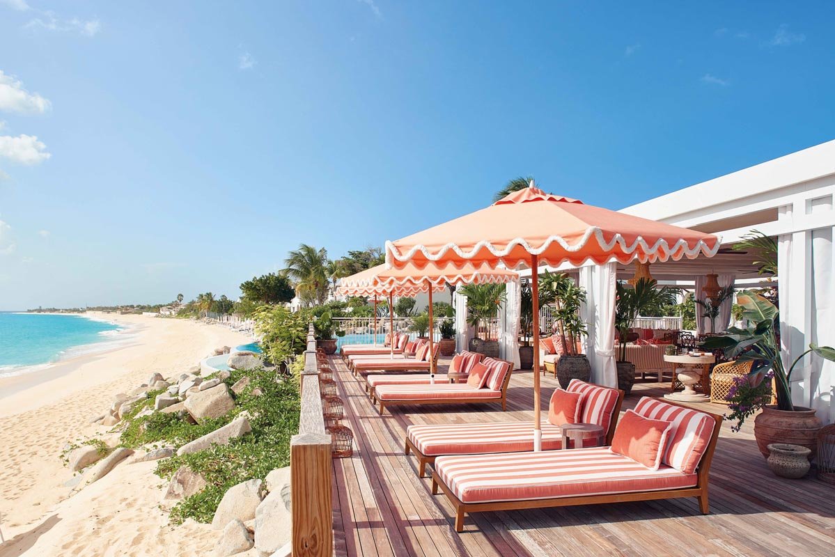 Poolside restaurant terrace with sunbeds and ocean view, Belmond La Samanna, St. Maarten