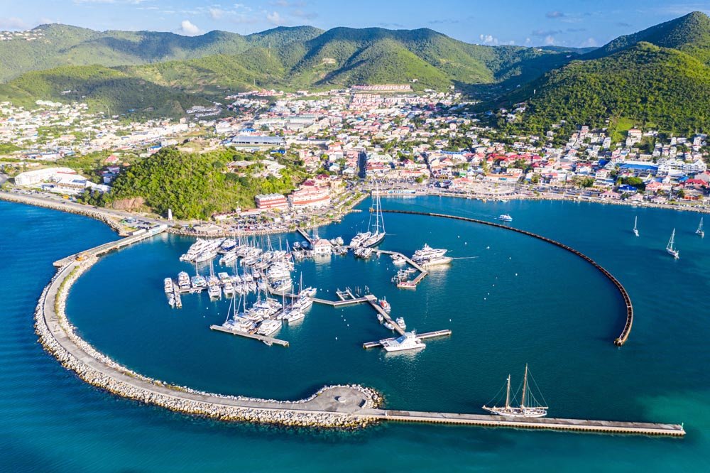 “Explore the Captivating Aerial View of Marigot – The Dual Capital of Saint Martin” Arial view of Marigot, the main town and capital in the French Saint Martin, sharing the same island with dutch Sint Maarten. Fort St. Louis on a hill, yachts and a circular breakwaters of the marina.