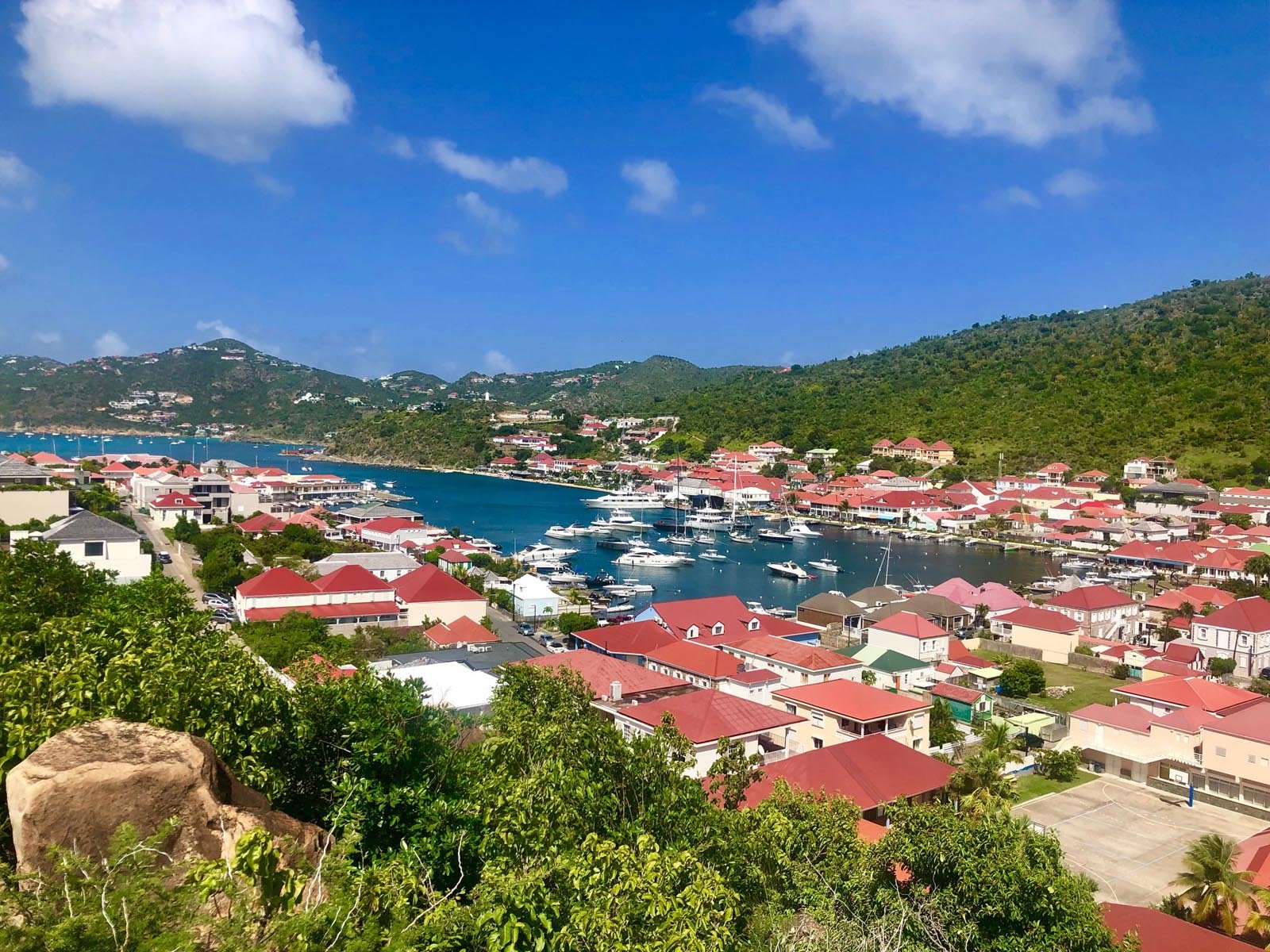 Luchtfoto van de haven van Gustavia op St. Barths met kleurrijke daken en een turquoise zee.