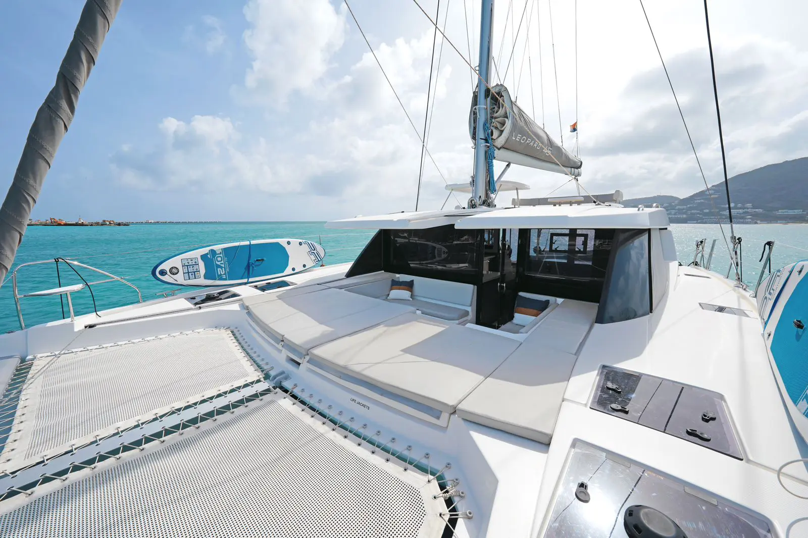 Bow of Leopard 45 sail catamaran cutting through St. Maarten waters at sunrise