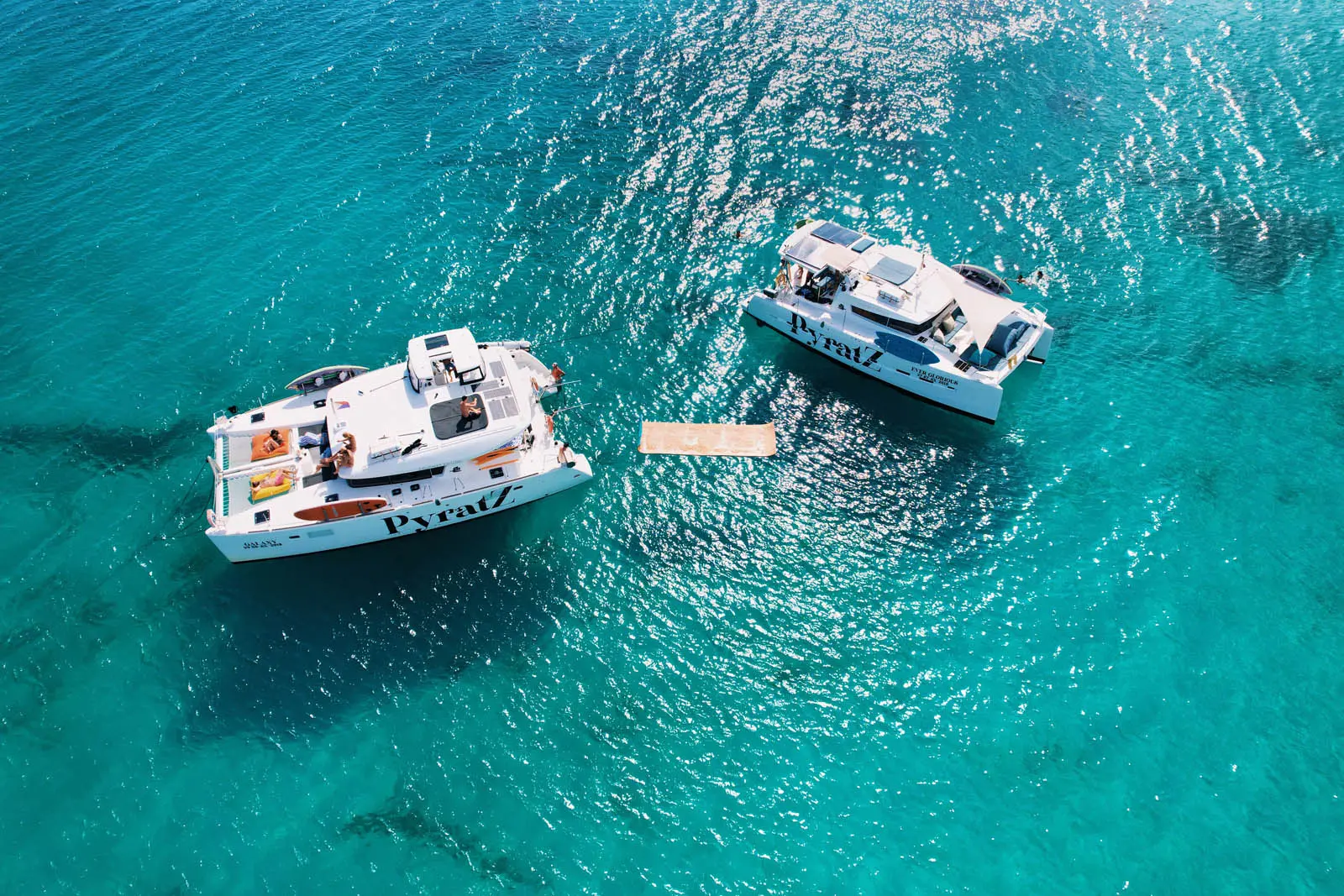 Lagoon 450S power catamaran 'Galaxy' anchored in turquoise waters off St. Maarten, showcasing paddle boards, a kayak, and a floating mat.