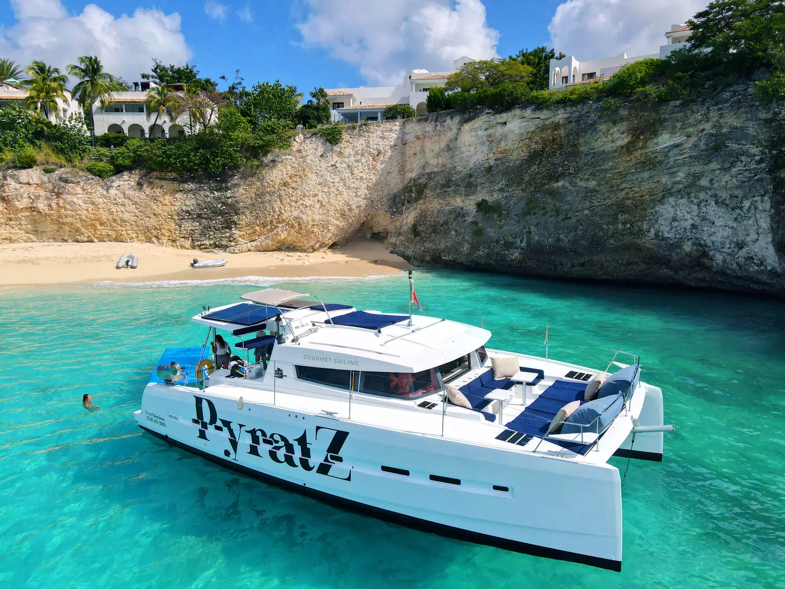 Lagoon 450S power catamaran 'Galaxy' anchored in turquoise waters off St. Maarten, showcasing paddle boards, a kayak, and a floating mat