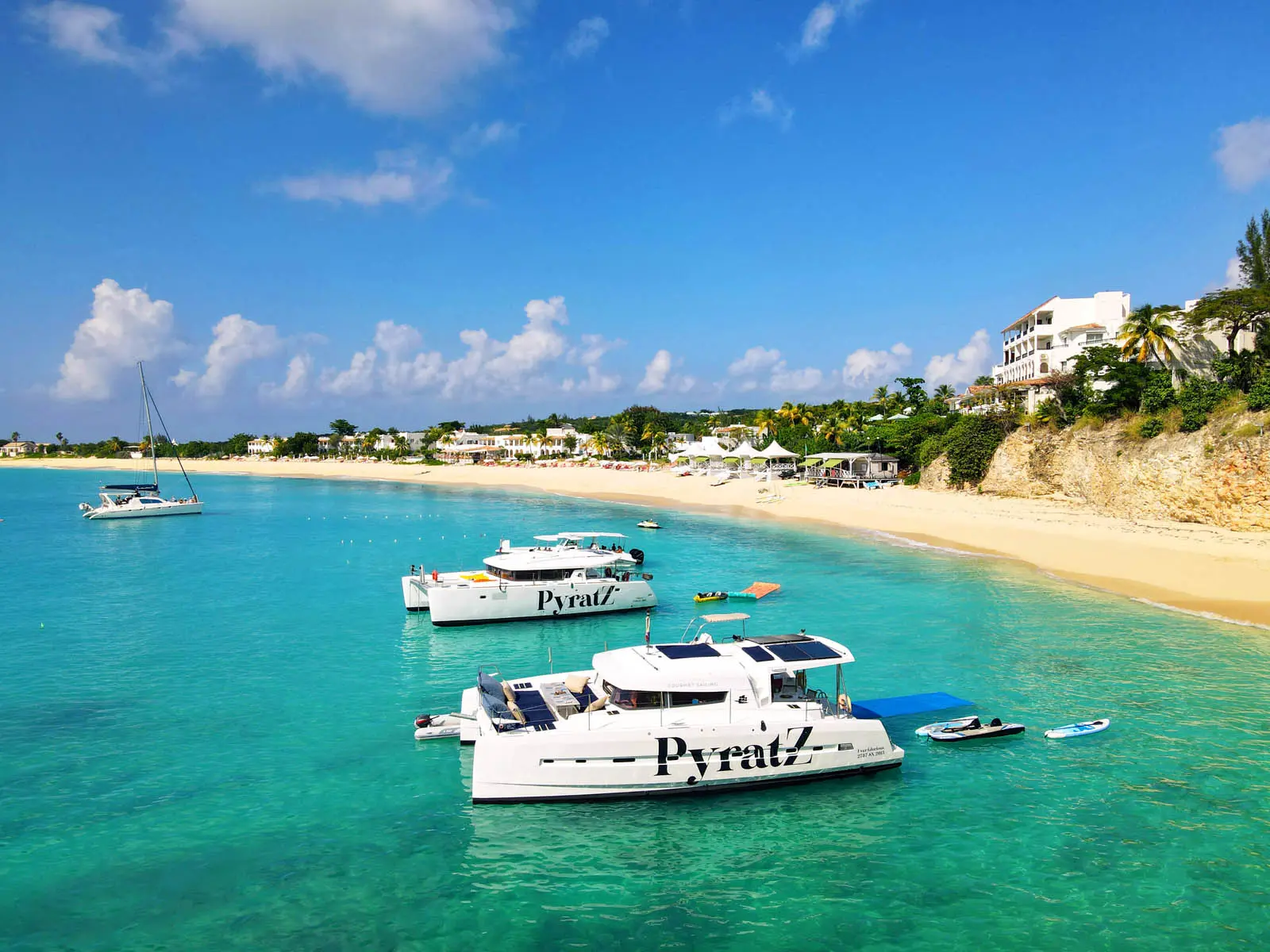 Lagoon 450S power catamaran 'Galaxy' anchored in turquoise waters off St. Maarten, showcasing paddle boards, a kayak, and a floating mat